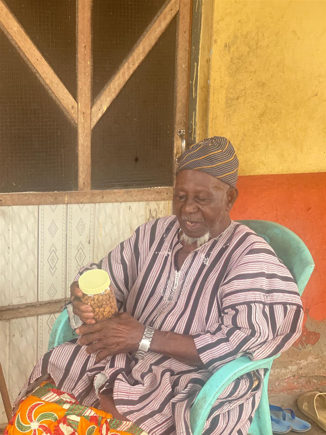 An elder holding a jar of Influx groundnut product